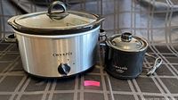 Medium and small Crock-Pots placed side by side showing their exterior and lids.