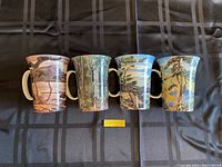 Front and side view of four McIntosh Galley mugs showing detailed scenic designs.