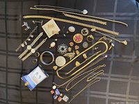 Overview of assorted jewelry pieces laid out on black surface