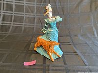 Front view of the Royal Doulton Autumntime figurine showing woman in teal dress with dog beside her.