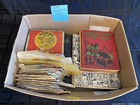 Photo of the box containing three vintage stamp albums and multiple loose envelopes used for stamps storage.