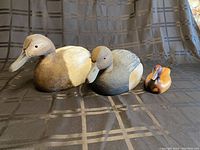 Front and side view of three wood duck decoys showing colors and carving detail.