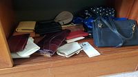 Top shelf with collection of ladies bags, vintage clutches, and change purses in various colors and styles.