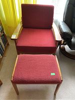 Front view of chair and footrest showing red upholstery and wood frame