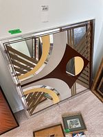 Front view showing full mirror face, geometric arcs, stripes and central circular inset.