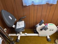 Side view of white Tunturi F530 semi-recumbent exercise bike showing adjustable seat, backrest, and pedals with straps.