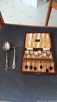 Complete set of toddler utensils and coffee spoons with case arranged on textured surface