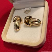 Front view of both earrings displayed in a velvet-lined box