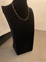 Necklace draped on black display bust showing overall length and drape.