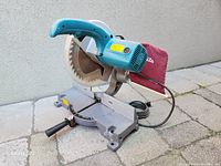 Side and top view showing 255mm blade, blue handle, gray base, and dust collection bag.