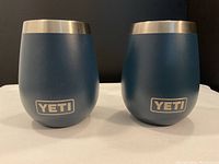 Two blue YETI insulated wine tumblers with stainless steel rims and YETI logo on front, front view