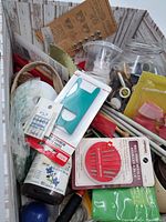 Overview of sewing supplies including needles, elastic bands, buttons, thread and knitting needles in a wooden crate.