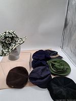 Group photo of 7 assorted vintage hats showing various styles and colors including floral, textured, fuzzy, and solid cloth hats.