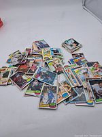 Multiple assorted vintage hockey cards scattered on a white surface showing card fronts with colorful borders and various player images.