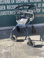 Side angle view of the walker showing one side of the frame and front wheels.