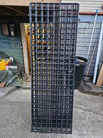 Front view of multiple metal grid racking panels stacked vertically showing grid pattern and size.