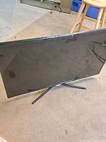 Front view of Samsung 40-inch TV showing screen and stand on carpet.