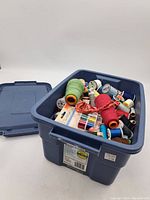 Blue Rubbermaid Roughneck storage tote filled with assorted sewing threads and lid off to the side.