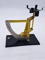 Full view of the vintage kitchen scale showing the yellow arm, black base, and weighing platform.