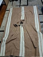 Full view of wool poncho laid flat showing the overall shape and vertical stripes pattern.