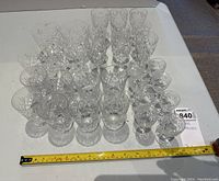 Overview of entire crystal glassware set displayed with measuring tape for size reference