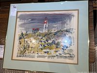 Framed original watercolour painting showing Cape Cod lighthouse scene with landscape and buildings, mounted under glass.