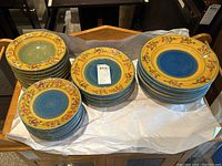 Overview of three stacks showing green-centered bowls on left, medium plates in center and dinner plates on right