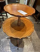 Two-tier wooden side table with scalloped edges, showing top view and overall structure