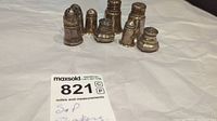 Front view of six assorted sterling silver salt and pepper shakers of different sizes and styles.