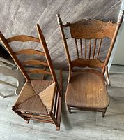 Two vintage wooden chairs side by side, one a rocking chair with carved backrest and the other ladder-back with woven seat