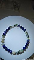 Natural gemstone stretchy bracelet arranged in a circle showing alternating Tree Agate and Lapis Lazuli beads.