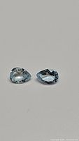 Pair of pear cut sky blue topaz gemstones, clear with high clarity, shown from the top angle.