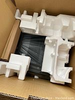 View inside the box showing the black Brother printer securely packed with styrofoam inserts to protect during shipping.