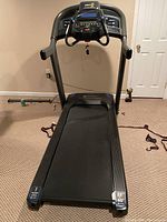 Photo of the treadmill fully assembled showing running belt and console with control panel and handrails.