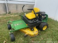 Side-front view showing mower deck, seat, and steering levers
