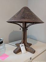 Overall view of table lamp showing wooden base and conical metal shade