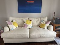 Front view of cream twill sofa with throw pillows