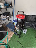 Full view of Craftsman power washer unit with hose, power cord, and visible engine. Located on green turf near equipment rack.