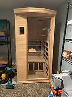 Full front view of sauna showing wood exterior, glass door and control panel