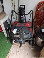 Front view of the snow blower showing control panel, start dial, and chute.