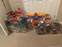 Overall lot grouping: Duplo tub, Magna Tiles tote, two Nerf blasters, Erector Hummer H2 box, Jada Battle Machines box