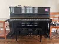 Front view of upright piano and bench