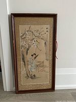Full view of the framed antique Chinese silk painting showing a woman playing an instrument under a blossoming tree, mounted in wood frame with minor scratches.