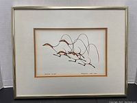 Framed art print showing stylized birds in flight with white matting and thin silver metal frame.