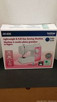 Box of Brother JX1400 lightweight full size sewing machine showing model, features and warranty information.