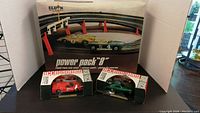 Eldon Power Pack "8" track set with 2 slot cars on track and two boxed slot cars in front