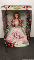 Full view of Rose Barbie doll in original box showcasing packaging and doll dress details.