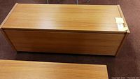 Top and side view of teak laminate hope chest showing exterior finish and general shape.