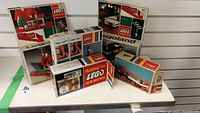 Six cardboard boxes containing vintage LEGO sets and parts displayed on shelf