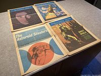 Four Star Weekly Novels laid out on a surface showing cover art for each issue.